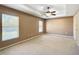 Spacious main bedroom with neutral walls, carpet, ceiling fan, and bright windows creating a serene atmosphere at 15069 Sw 29Th Avenue Rd, Ocala, FL 34473