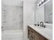 Bathroom featuring white tile walls, a shower-tub combo and a wood vanity with a white marble top at 1590 Twelve Oaks Cir, Kissimmee, FL 34744