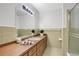 Bathroom featuring a shower and vanity with drawers and cabinet space, all accented by a tiled wall at 1590 Twelve Oaks Cir, Kissimmee, FL 34744