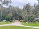 Scenic driveway leads to a home surrounded by mature trees and lush landscaping, offering a peaceful entrance at 1590 Twelve Oaks Cir, Kissimmee, FL 34744