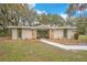 Charming single-story home with stone accents, green trim, and a welcoming walkway to the front door at 1590 Twelve Oaks Cir, Kissimmee, FL 34744