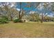 Spacious front yard with mature trees and lush landscaping, offering a tranquil setting at 1590 Twelve Oaks Cir, Kissimmee, FL 34744