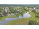 Scenic aerial view of a neighborhood surrounding a pond surrounded by grass at 1686 Shadowmoss Cir, Lake Mary, FL 32746