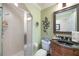 Well-lit bathroom with a stand-up shower featuring glass doors and a dark vanity with a black granite countertop at 1686 Shadowmoss Cir, Lake Mary, FL 32746