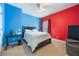 A bedroom with red and blue walls, natural lighting, and a ceiling fan at 1686 Shadowmoss Cir, Lake Mary, FL 32746