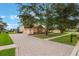 Well-manicured front yard with a brick driveway leading to the home's three-car garage at 1686 Shadowmoss Cir, Lake Mary, FL 32746