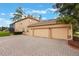 Exterior featuring a spacious three-car garage and beautiful brick driveway with well-kept landscaping at 1686 Shadowmoss Cir, Lake Mary, FL 32746
