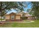 Beautiful home with stone accents and a curved pathway leading to the entrance, framed by mature trees at 1686 Shadowmoss Cir, Lake Mary, FL 32746