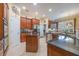 Open kitchen features dark granite counters, stainless appliances, tile floors, and wood cabinetry at 1686 Shadowmoss Cir, Lake Mary, FL 32746