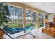 Bright sun room with expansive windows, tile floors and hammock, with a view of the screened pool at 1686 Shadowmoss Cir, Lake Mary, FL 32746