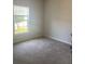 Light-filled bedroom featuring a large window, neutral paint, and plush carpet flooring at 1707 Ambar Ct, Winter Haven, FL 33881