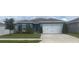 Charming single-story home with a well-maintained lawn, mature trees, and a two-car garage at 1707 Ambar Ct, Winter Haven, FL 33881