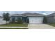 Charming single-story home with a well-maintained lawn, mature trees, and a two-car garage at 1707 Ambar Ct, Winter Haven, FL 33881