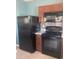 Efficient kitchen with black appliances, wooden cabinetry, and tiled backsplash at 1707 Ambar Ct, Winter Haven, FL 33881