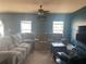 Spacious living room with a ceiling fan, windows, and comfortable seating arrangement at 1707 Ambar Ct, Winter Haven, FL 33881