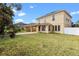 Spacious backyard showcasing the home's architecture, manicured lawn, and brick-paved patio at 2020 Windcrest Lake Cir, Orlando, FL 32824