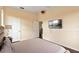 Cozy bedroom featuring a wall-mounted TV, neutral walls, and two entry doors at 2020 Windcrest Lake Cir, Orlando, FL 32824