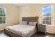 Bedroom with a contemporary bed, a nightstand, and natural light from two large windows at 2020 Windcrest Lake Cir, Orlando, FL 32824