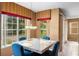 Bright dining area with a marble table, blue chairs, and a view of the outdoors through large windows at 2020 Windcrest Lake Cir, Orlando, FL 32824