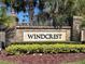 A welcoming Windcrest community sign with colorful landscaping and well-maintained surroundings at 2020 Windcrest Lake Cir, Orlando, FL 32824