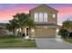 Charming two-story home featuring a two-car garage, lush landscaping, and a beautifully maintained lawn at 2020 Windcrest Lake Cir, Orlando, FL 32824