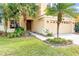 This house features mature landscaping, including Palm trees, and a two car garage at 2020 Windcrest Lake Cir, Orlando, FL 32824