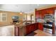 Well-equipped kitchen featuring a breakfast bar, stainless steel appliances, and cherry wood cabinets at 2020 Windcrest Lake Cir, Orlando, FL 32824