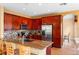 Spacious kitchen with cherry cabinets, granite counters, and a stainless steel refrigerator at 2020 Windcrest Lake Cir, Orlando, FL 32824