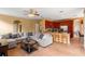 Open-concept living room with tile floors, a large sectional sofa, and a kitchen with wood cabinets at 2020 Windcrest Lake Cir, Orlando, FL 32824
