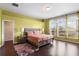 Sunlit main bedroom with hardwood floors, a king-size bed, and three large windows at 2020 Windcrest Lake Cir, Orlando, FL 32824