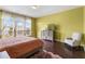 Spacious main bedroom features a large window, a dresser with TV, a chair and dark wood floors at 2020 Windcrest Lake Cir, Orlando, FL 32824