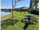 Picturesque pond view with green picnic tables and umbrellas in a well-maintained community area at 2020 Windcrest Lake Cir, Orlando, FL 32824