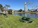 Picturesque pond view with green picnic tables and umbrellas in a well-maintained community area at 2020 Windcrest Lake Cir, Orlando, FL 32824