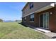 Spacious backyard with a lawn and waterfront view, accessible through sliding glass doors at 2120 Betsy Ross Ln, St Cloud, FL 34769