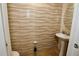 Modern half bathroom featuring unique textured tile, pedestal sink, and neutral color palette at 2120 Betsy Ross Ln, St Cloud, FL 34769