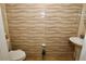 Modern half bathroom featuring unique textured tile, pedestal sink, and neutral color palette at 2120 Betsy Ross Ln, St Cloud, FL 34769