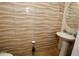 Stylish half-bathroom featuring elegant textured tile, pedestal sink, and neutral color palette at 2120 Betsy Ross Ln, St Cloud, FL 34769