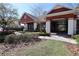 Inviting clubhouse entrance with red brick facade and covered walkway, surrounded by manicured landscaping at 2120 Betsy Ross Ln, St Cloud, FL 34769