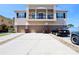 Exterior shot showing three-story townhome with garages, driveway, and second story balcony at 2120 Betsy Ross Ln, St Cloud, FL 34769