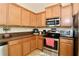 Well-lit kitchen featuring stainless steel appliances and warm-toned cabinets for a cozy feel at 2120 Betsy Ross Ln, St Cloud, FL 34769