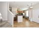 Bright open-concept living space featuring tile floors and stairs leading up, seamlessly flowing into the kitchen area at 2120 Betsy Ross Ln, St Cloud, FL 34769