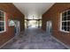 Community walkway featuring brick walls, tile flooring, and access to the exterior through glass doors and an archway at 2120 Betsy Ross Ln, St Cloud, FL 34769