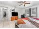 Bedroom featuring tile floors, a ceiling fan, and a TV, as well as access to another room at 2237 Avenue B Nw, Winter Haven, FL 33880