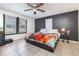 Comfortable bedroom with a ceiling fan, two windows, and a colorful quilt on the bed at 2237 Avenue B Nw, Winter Haven, FL 33880