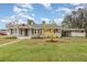 Charming single-story home with a well-maintained lawn and a covered carport, all under a sunny blue sky at 2237 Avenue B Nw, Winter Haven, FL 33880