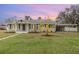 Charming single-story home with a well-maintained lawn and a covered carport, all under a beautiful sunset sky at 2237 Avenue B Nw, Winter Haven, FL 33880