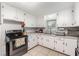 Functional kitchen with white cabinets, stainless steel appliances, and neutral countertops at 2237 Avenue B Nw, Winter Haven, FL 33880