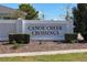 Canoe Creek Crossings community sign with manicured landscaping and clear blue sky at 2461 Bulrush Dr, St Cloud, FL 34769