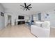 Comfortable living room with tile flooring, a ceiling fan, modern decor, and ample seating at 2461 Bulrush Dr, St Cloud, FL 34769