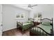 Cozy bedroom with two twin beds, wood floors, plantation shutters, and a ceiling fan at 2654 Derbyshire Rd, Maitland, FL 32751